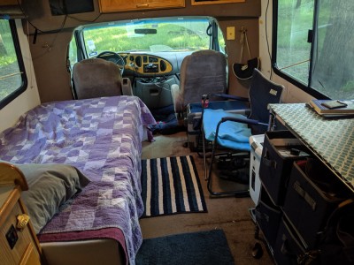 This is what the main living space looks like. The cooler-fridge works great as a side table for my drink, and I LOVE having room for a proper trash can!